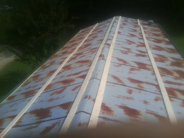 Rusted metal roof panels with new wood purlins before replacement — Storm Damage Roof Repair in Rockfall by Roofing Brothers