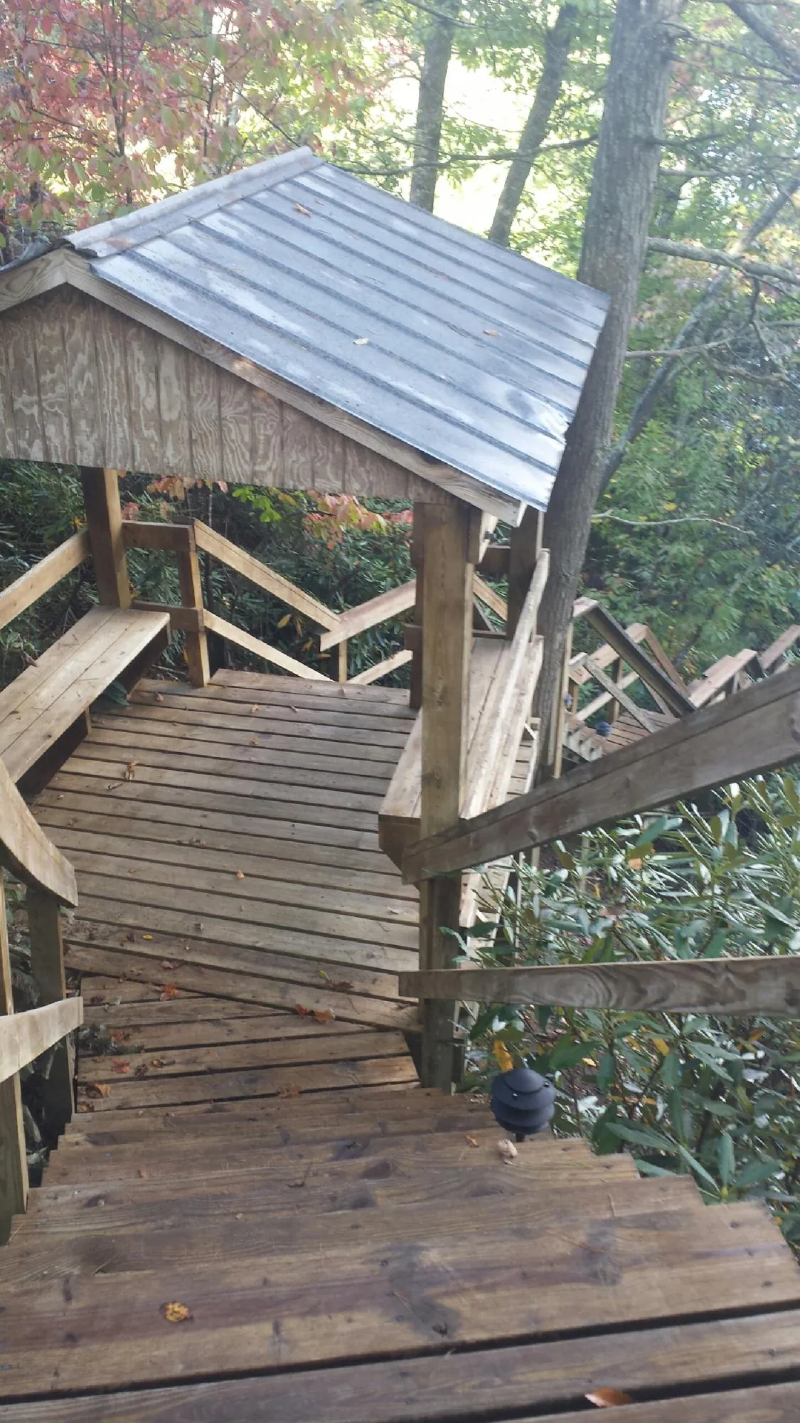 Metal roofed shelter over wooden steps on a wooded walkway — Skylight Repair & Installation work by our crew in Rockfall