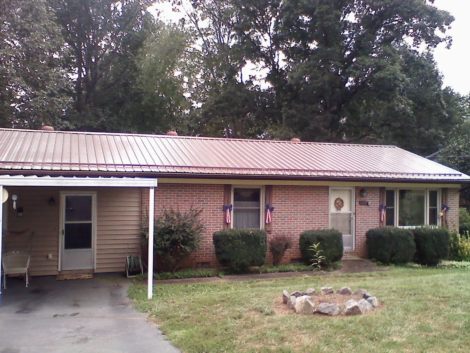 Bronze metal roof and carport on a brick ranch home — Roof Repair work by our crew in Rockfall